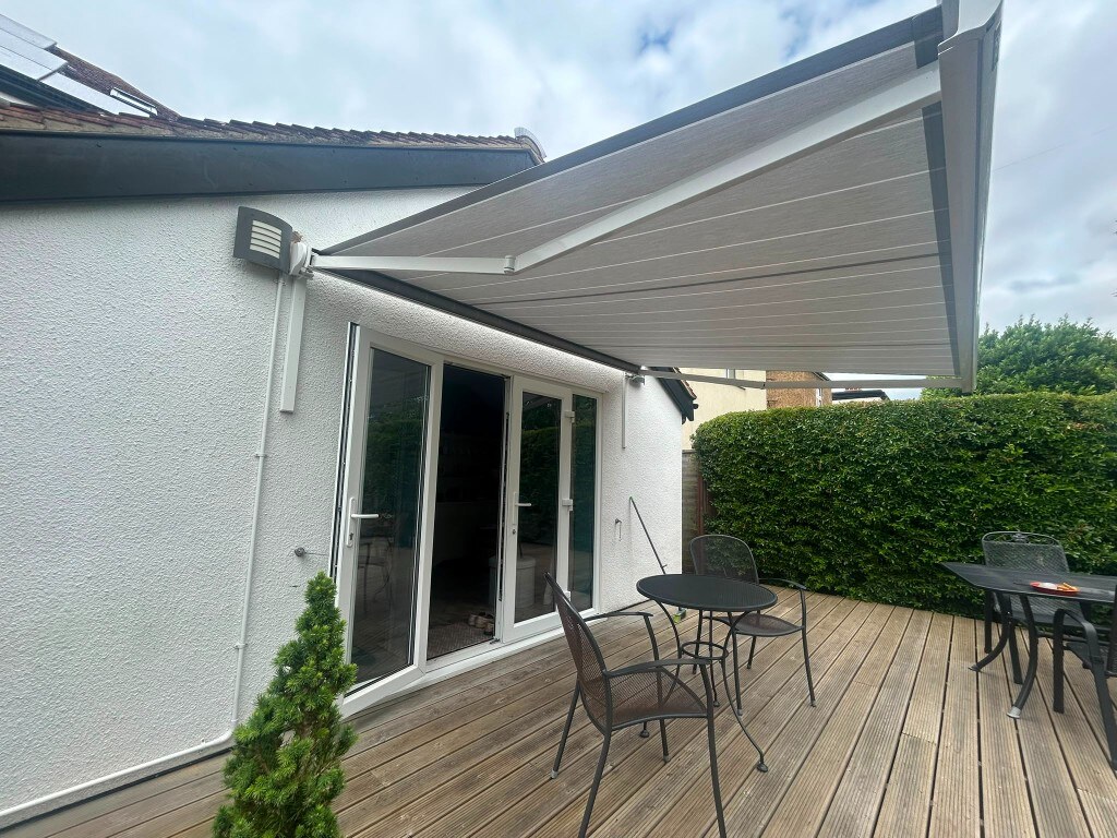 Bespoke white LoadBear spreader brackets supporting a retractable awning over a patio deck