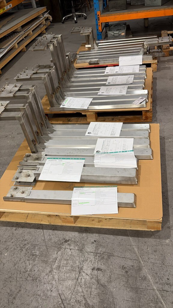 July batch of LoadBear custom brackets on pallets — spreaders, gutter brackets and sign brackets made to customer specifications