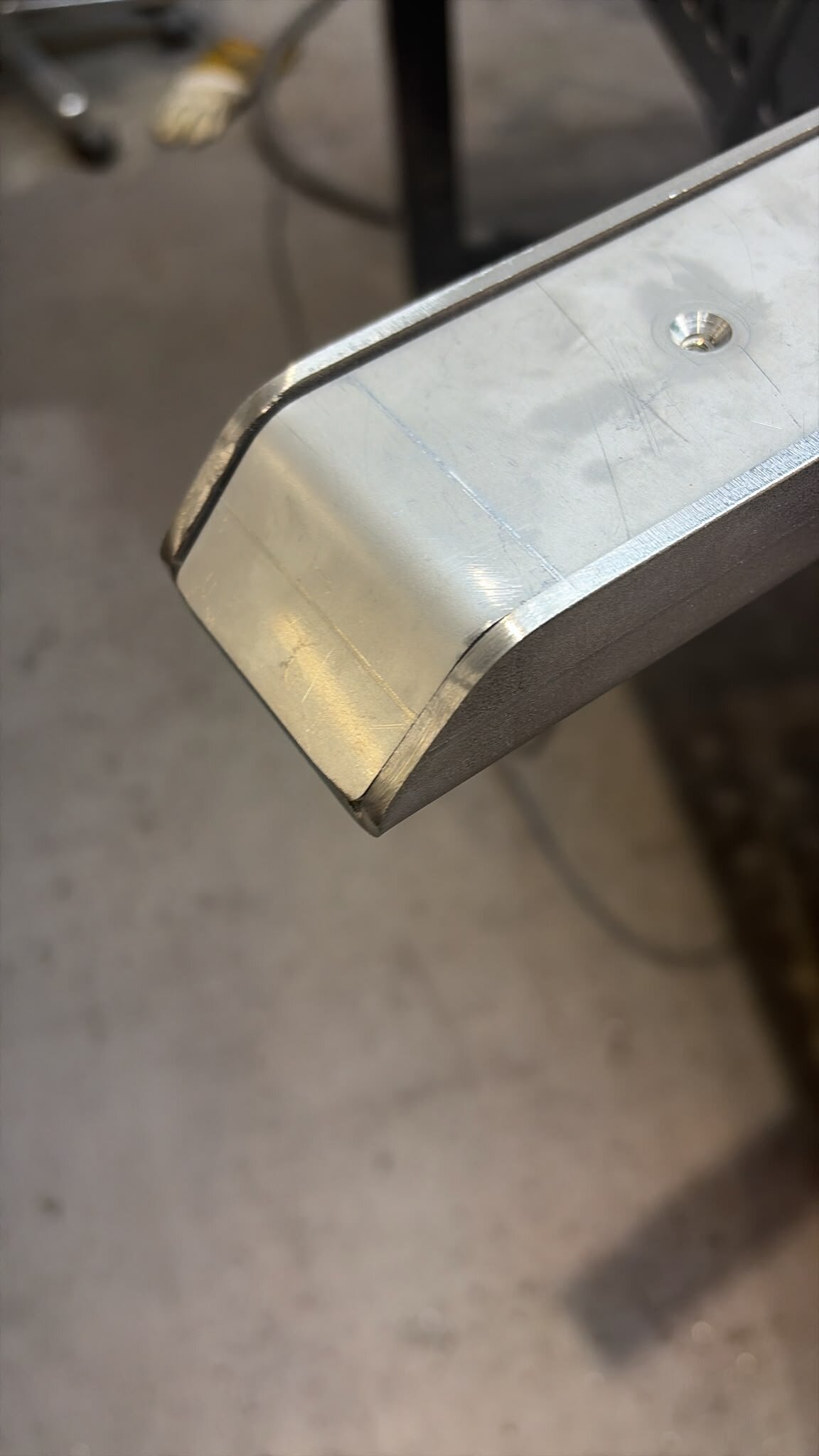 Close-up of a chamfered LoadBear bracket edge and countersunk fixing hole