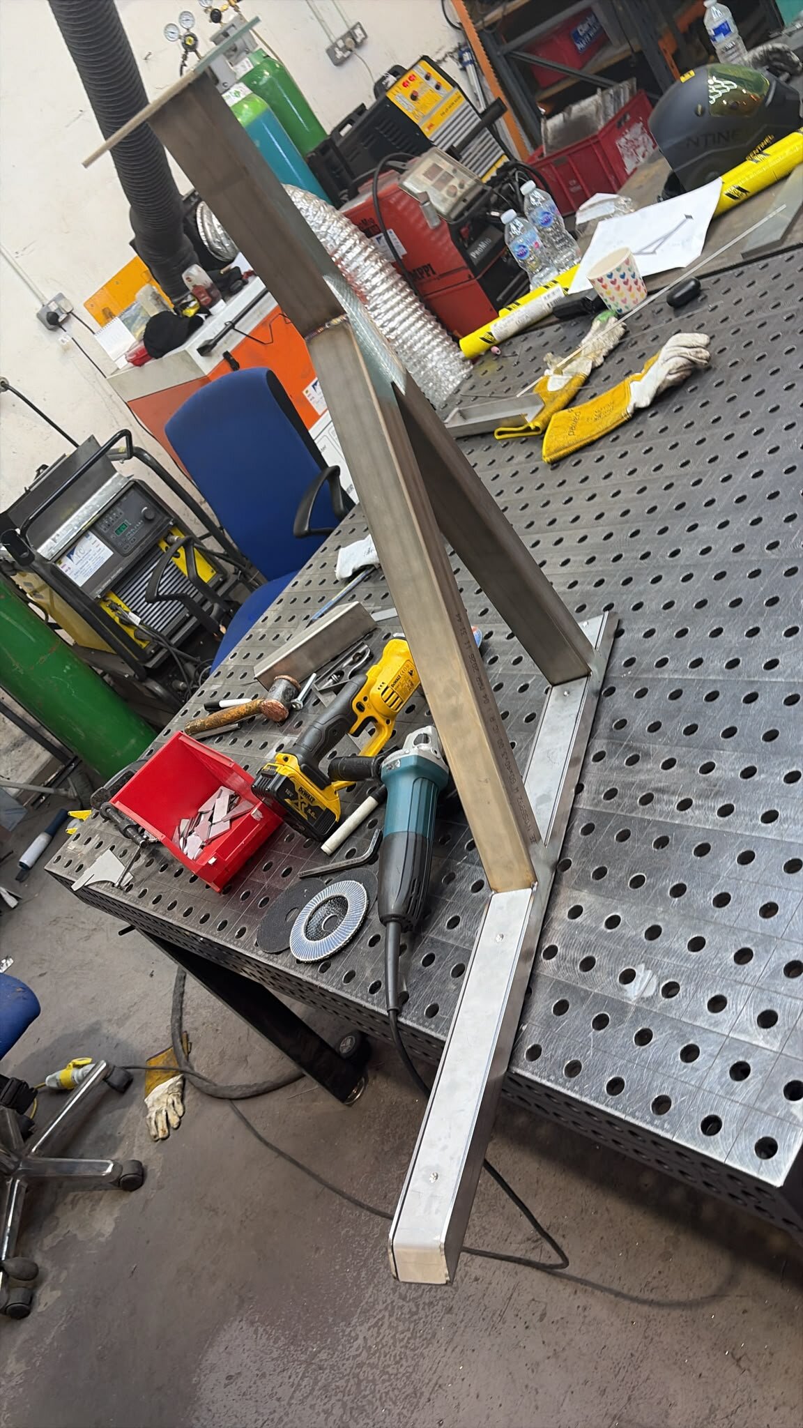 Reinforced LoadBear awning bracket on a welding fixture table with workshop tools
