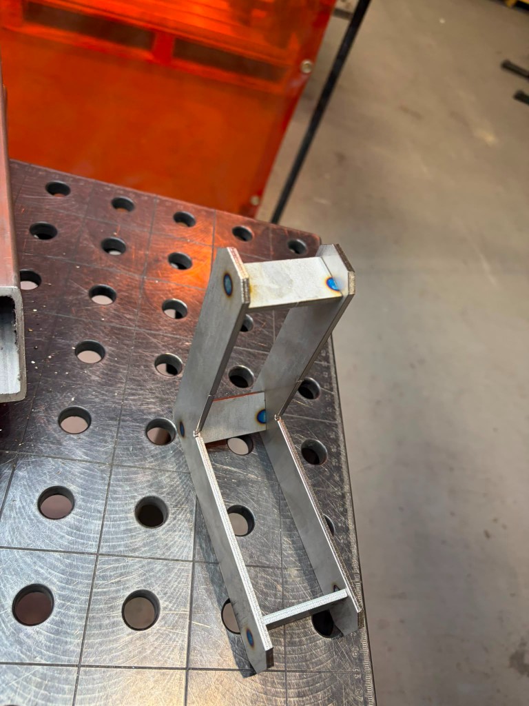 Internally reinforced LoadBear Extreme Gutter Bracket on a fabrication bench — dual-plate construction