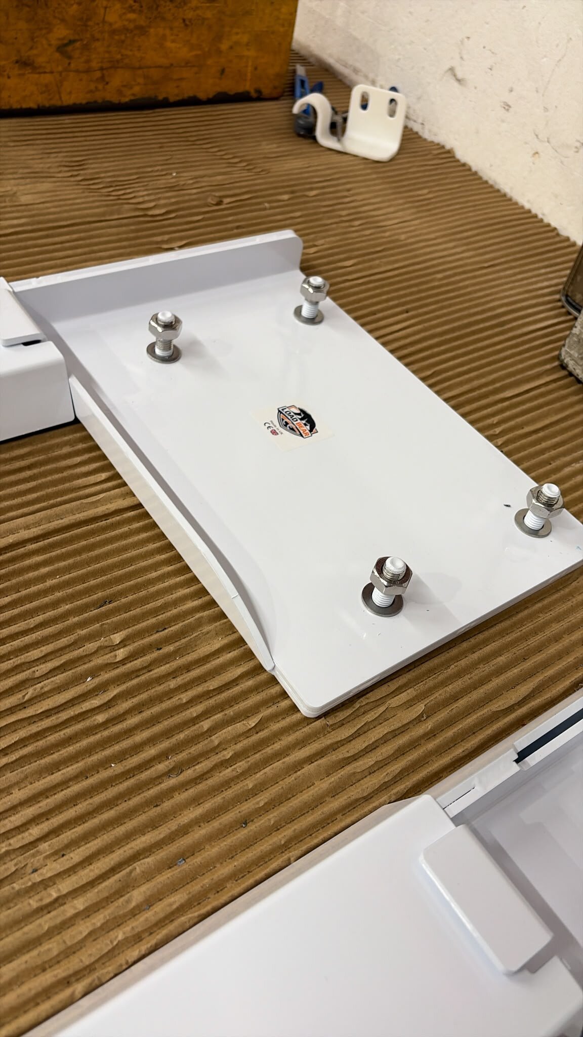 Close-up of LoadBear logo sticker with CE and UKCA marks on a white stud plate