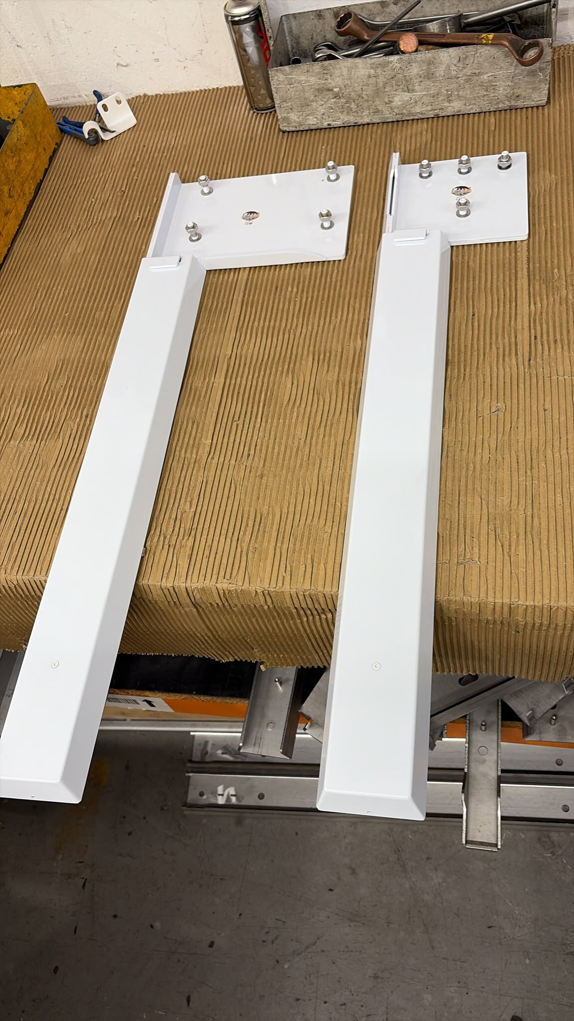Two white LoadBear box-section uprights with mounting plates side by side