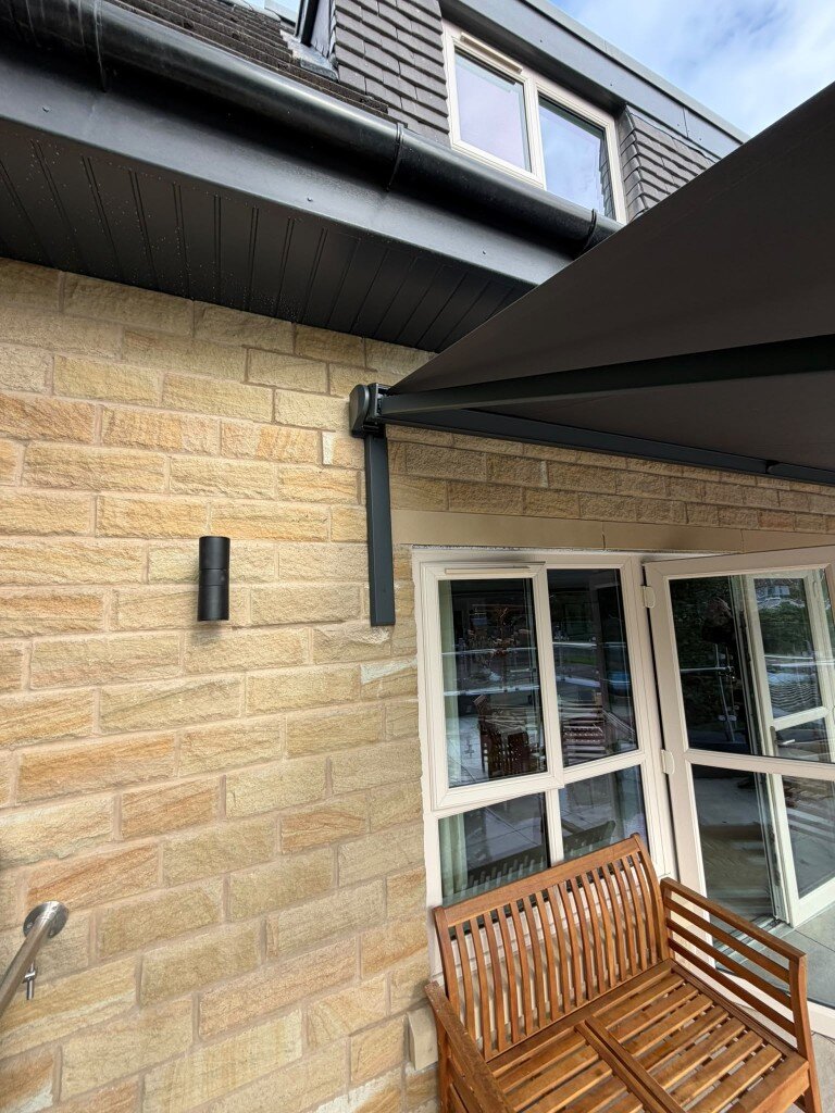 750 mm black LoadBear standard spreader bracket and awning arm on light stone