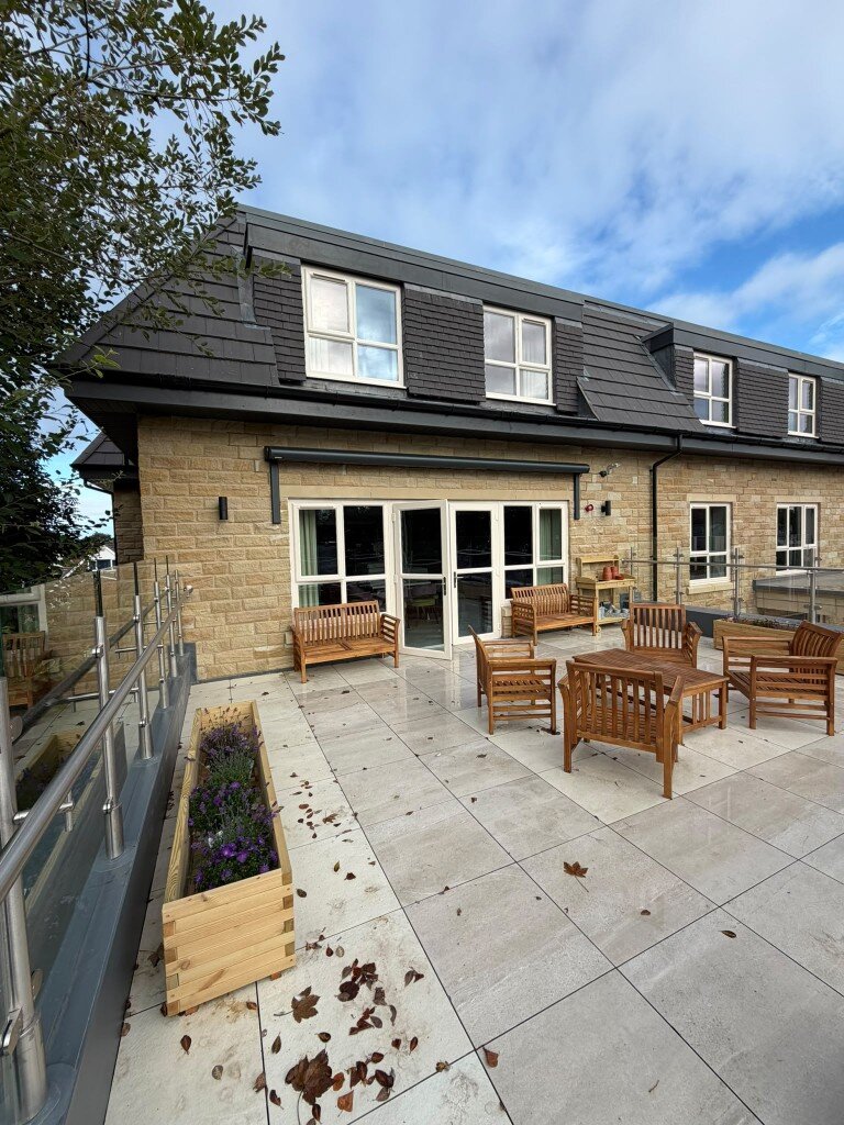 Black retractable awning on 750 mm LoadBear standard spreader brackets above patio doors