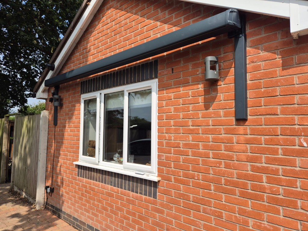 Front view of a bungalow awning supported by slim anthracite LoadBear wall brackets