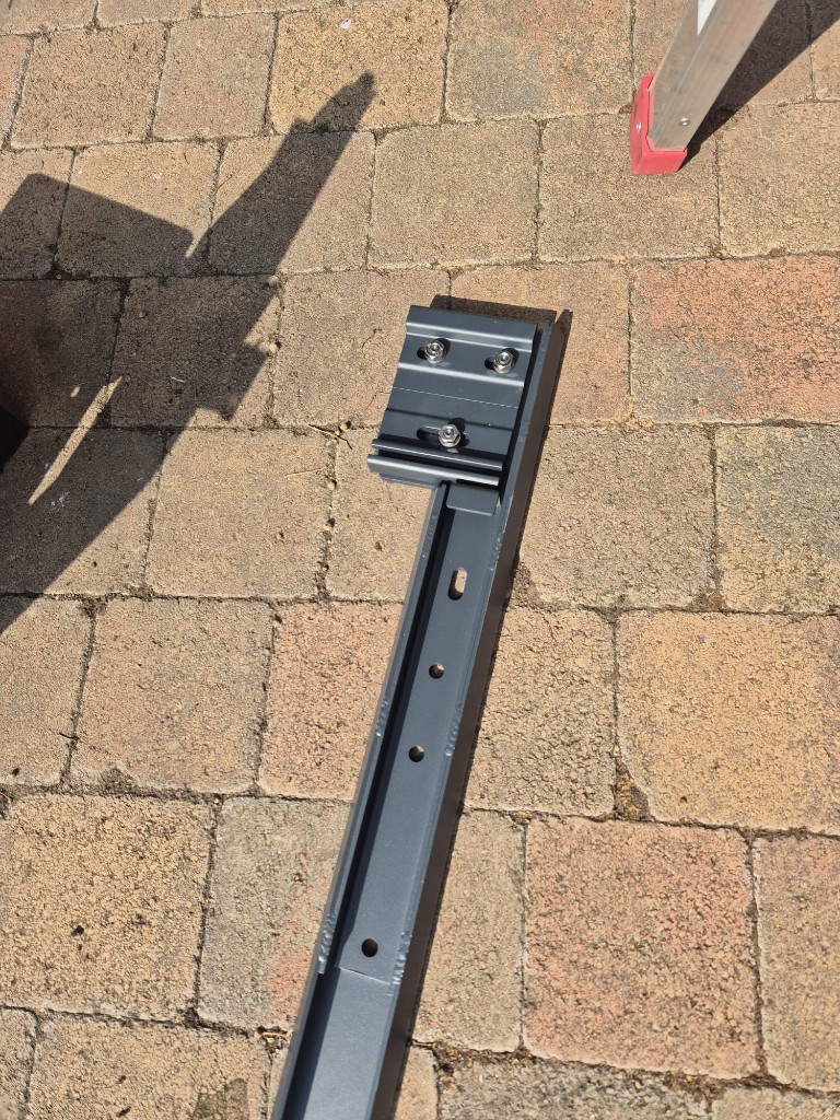 Left-hand LoadBear awning bracket fitted between exterior electrical and lighting fixtures