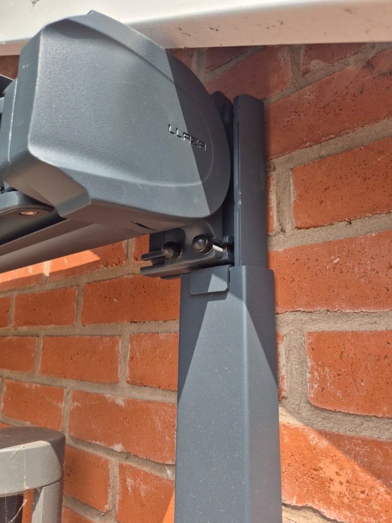 Slim anthracite LoadBear bracket cover fitted vertically against red brick