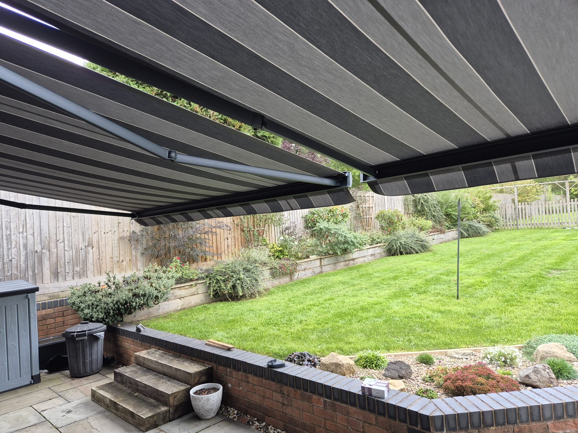 Garden view from under twin extended awnings on LoadBear gutter brackets