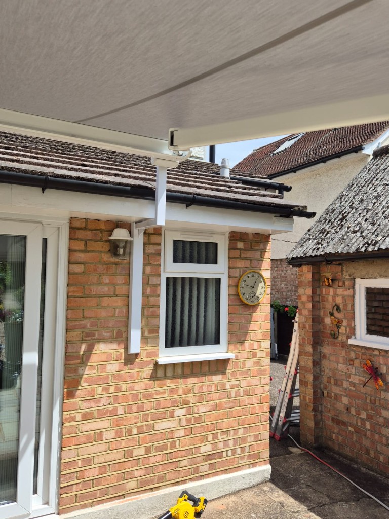 Mid shot of patio awning install with LoadBear bracket fixed between doors and window