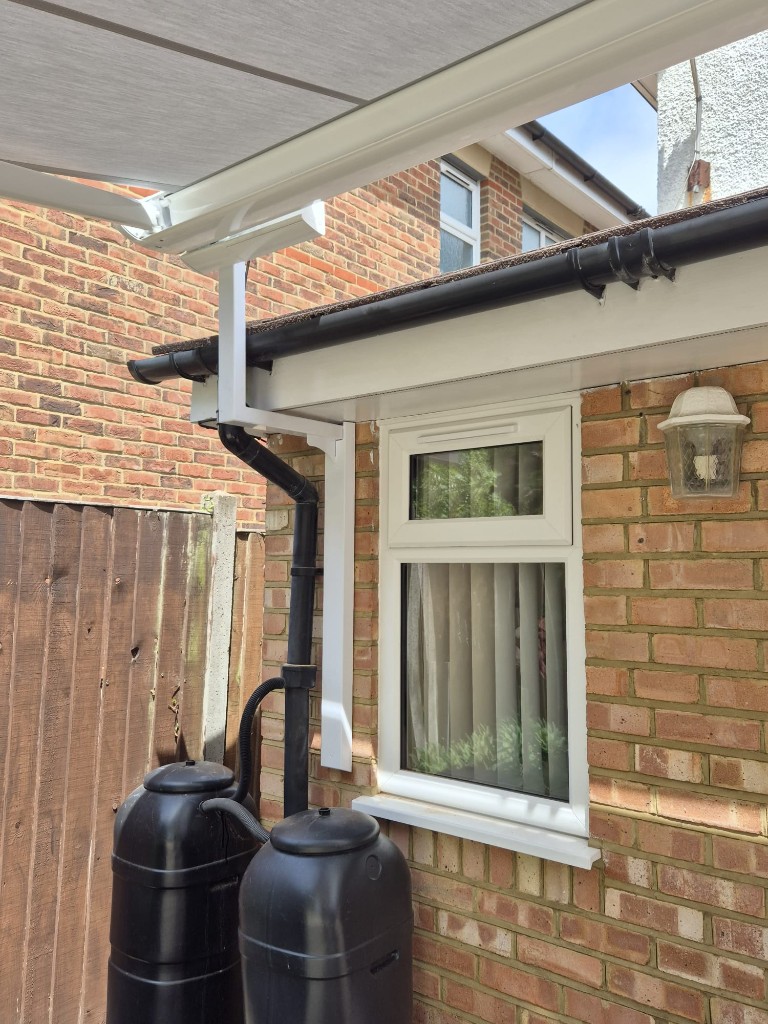 Side install mid shot — LoadBear bracket supporting a light grey awning cassette above a window